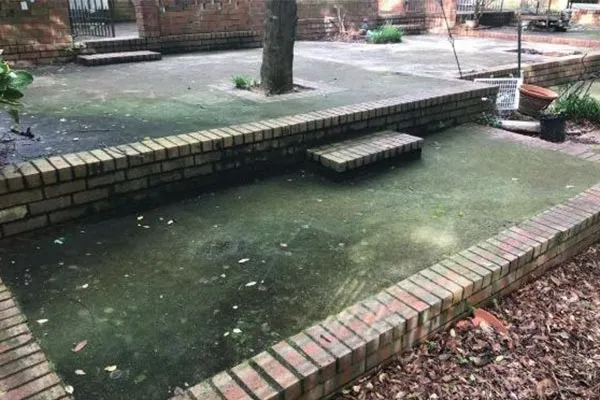 Lake Elsinore driveway covered in alkaline dust before pressure washing