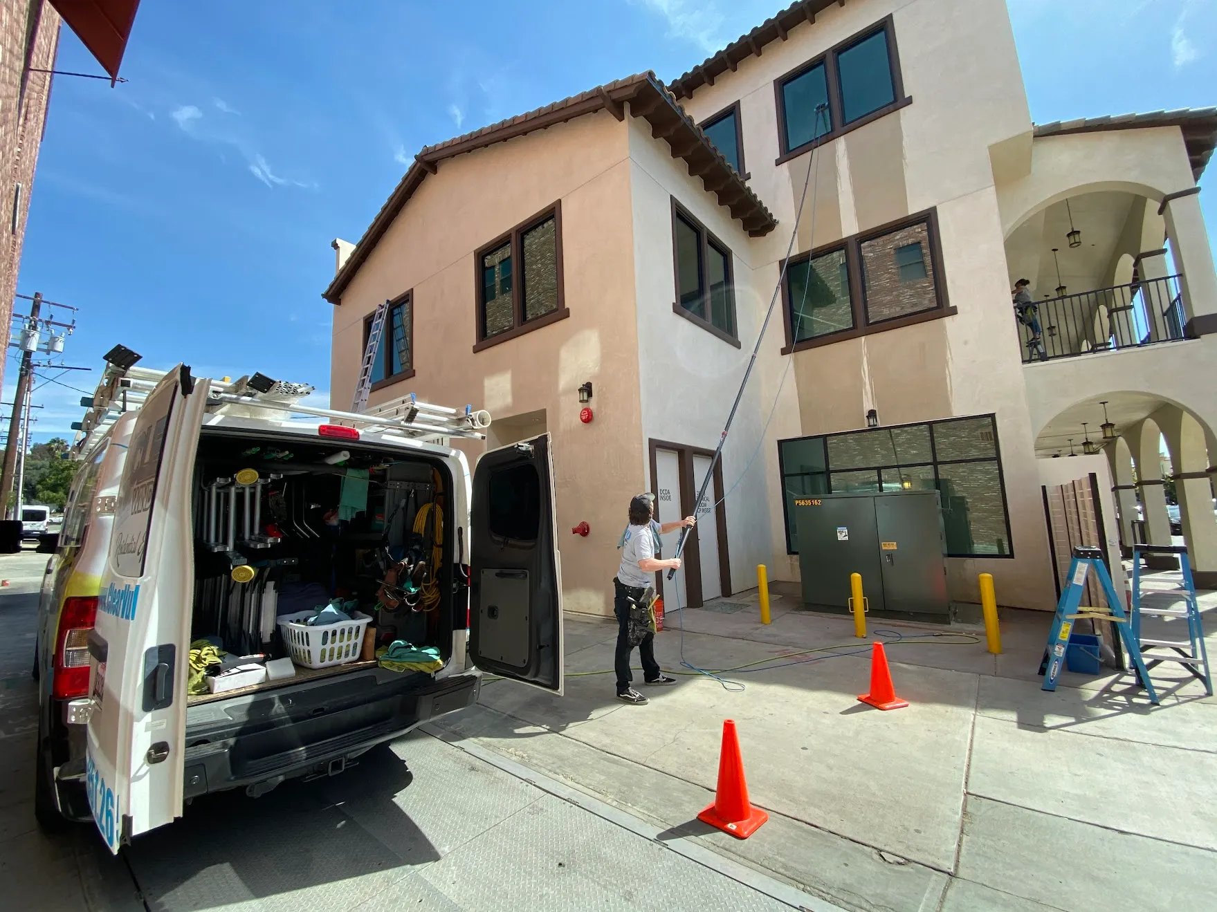 Clearvu technician using water-fed pole to clean commercial building windows in Old Town Temecula